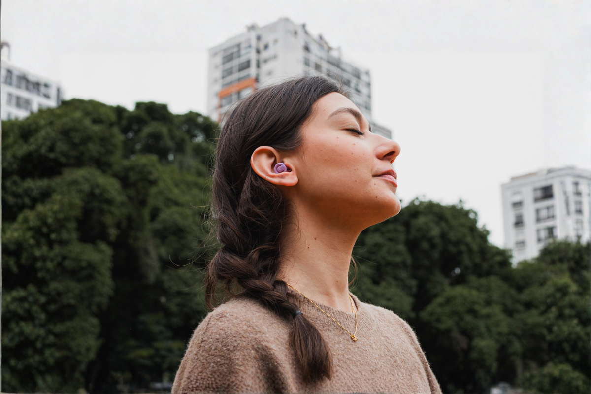 Mulher usando protetor auricular Mymute em ambiente urbano